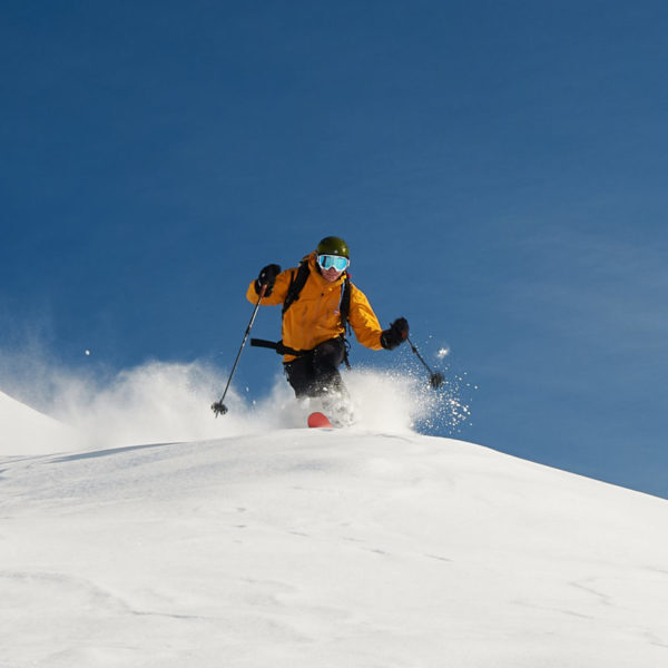 Front view of a male skier going off piste in Andermatt, the European alps.
